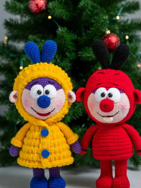 Две мягкие игрушки красного и жёлтого цвета под ёлкой